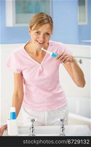 Woman cleaning teeth in bathroom