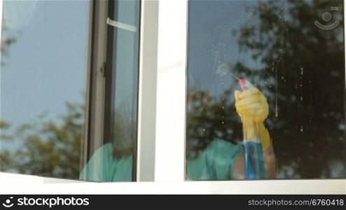Woman cleaning the window at home
