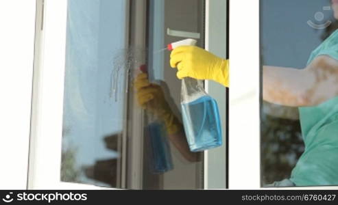 Woman cleaning the window at home