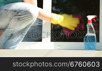 Woman cleaning the window at home