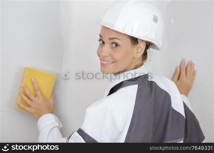woman cleaning wall before painting