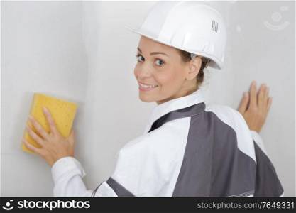 woman cleaning wall before painting