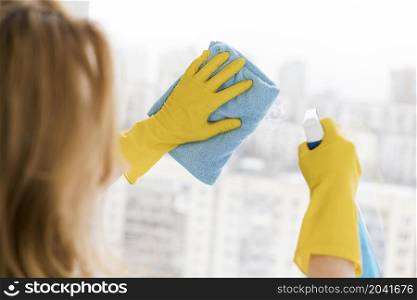woman cleaning window with rag