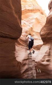 woman climb a ladder in the red canyon of israel near eilat. woman in the red canyon