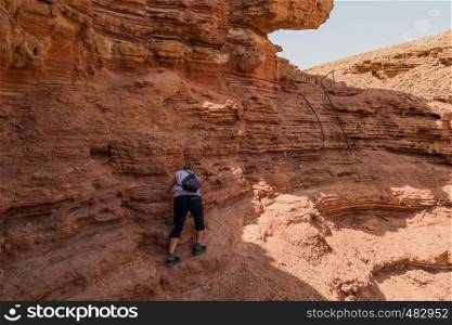 woman climbing in the red canyon in israel. woman climbing in the red canyon