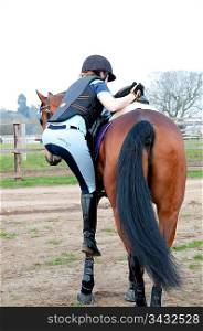 Woman climbing onto a horse