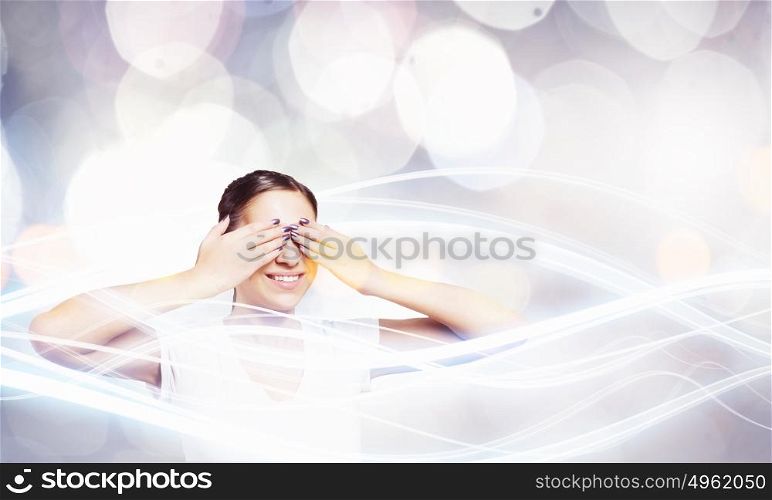 Woman closing eyes. Young woman in casual hiding eyes behind palms