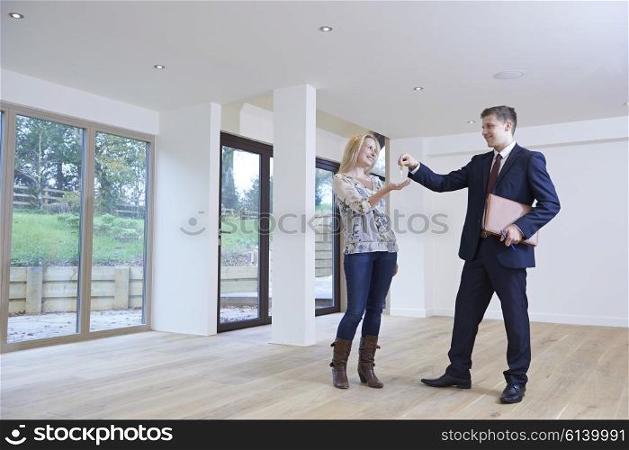 Woman Collecting Keys To New Home From Estate Agent
