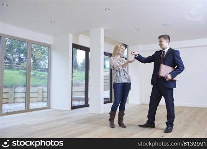 Woman Collecting Keys To New Home From Estate Agent