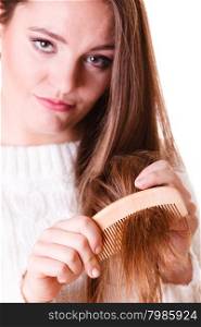 Woman combing and pulls hair.. Dissatisfied woman combing with brush and pulls at her long hair. Being unhappy for nice look in daily activity.