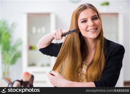 Woman combing her hair at home preparing for party