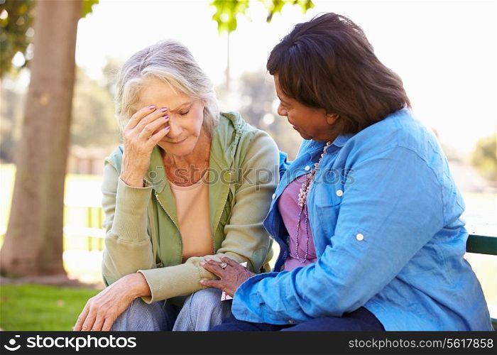Woman Comforting Unhappy Senior Friend Outdoors