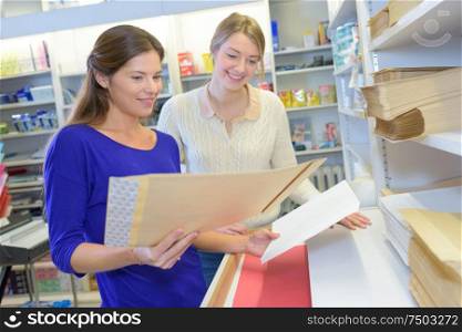Woman comparing envelopes in store