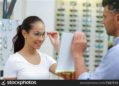woman comparing glasses at optician