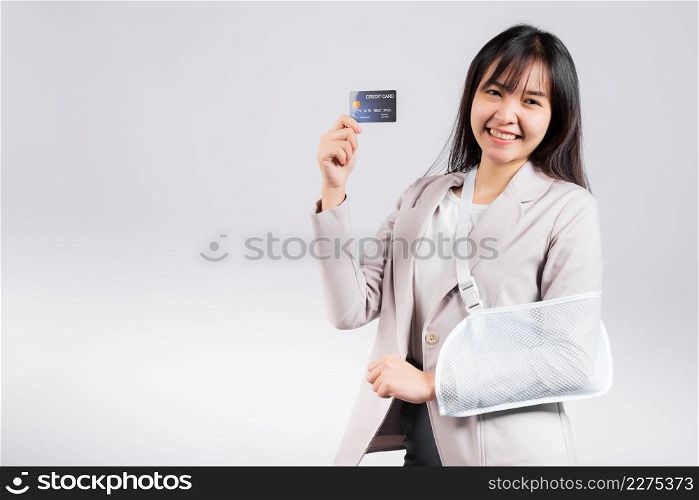 Woman confident smile broken arm after accident and wear arm splint for treatment she emergency pay medical bills by credit card, Happy Asian female sling support hand isolated on white background
