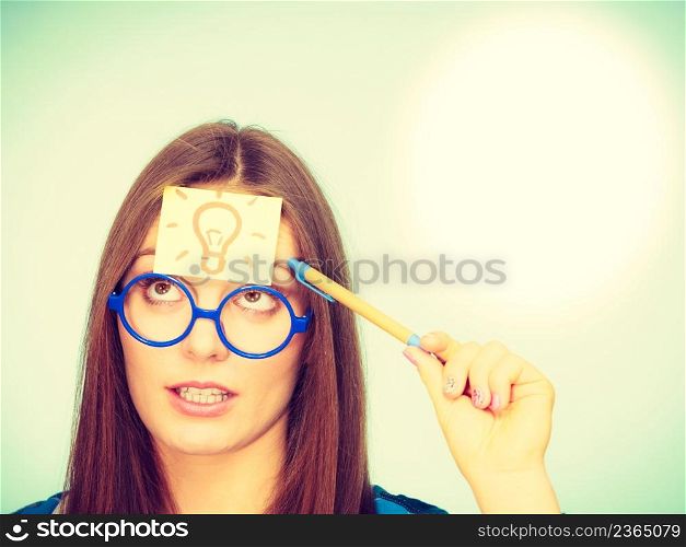 Woman confused thinking seeks solution, paper card with light idea bulb on her head. Girl is trying to create a new idea for some business project or case study studio shot on green. woman thinking light idea bulb on head