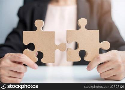 Woman connecting couple puzzle piece, wood jigsaw on table. Business solutions, mission, success, goals and strategy concepts
