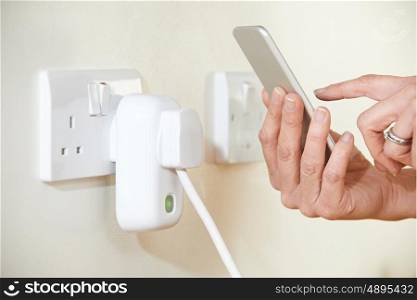 Woman Controlling Smart Plug Using App On Mobile Phone
