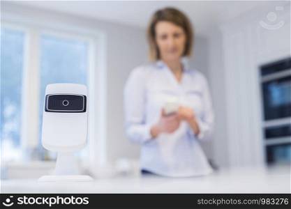 Woman Controlling Smart Security Camera Using App On Mobile Phone