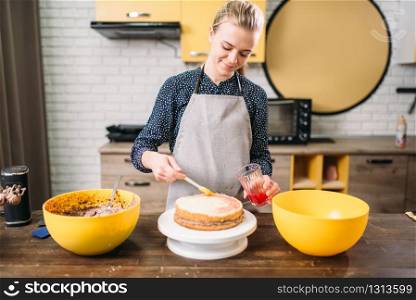 Woman cook hands smears filling for cake. Tasty dessert homemade cooking. Woman cook hands smears filling for cake