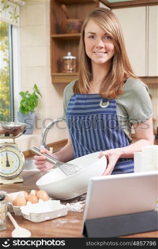 Woman Cooking And Following Recipe On Digital Tablet