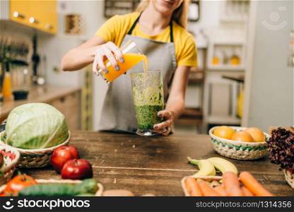 Woman cooking cocktail of fruit and vegetables on the kitchen, healthy organic food in a glass. Vegetarian diet. Woman cooking cocktail of fruit and vegetables
