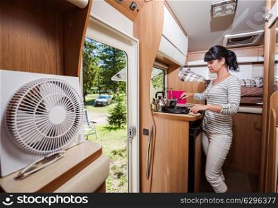 Woman cooking in camper, motorhome RV interior. Family vacation travel, holiday trip in motorhome, Caravan car Vacation.