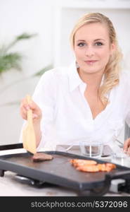 Woman cooking seafood and meat on a plancha