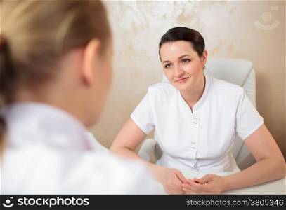 Woman cosmeticians having a professional conversation in the office room
