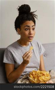 woman couch watching tv eating chips