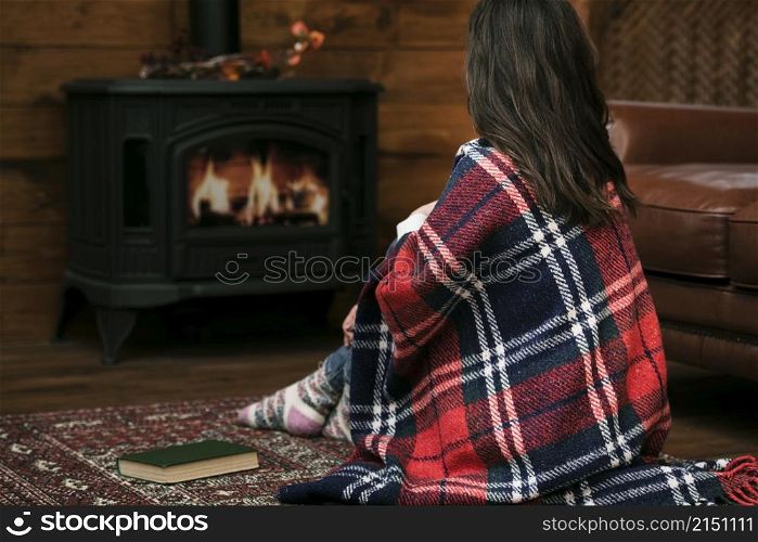 woman covered blanket fireplace