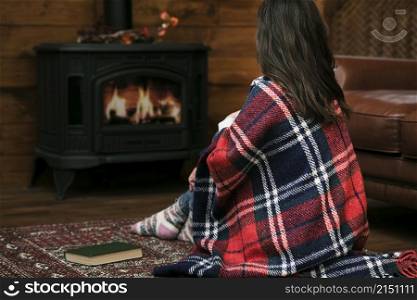 woman covered blanket fireplace