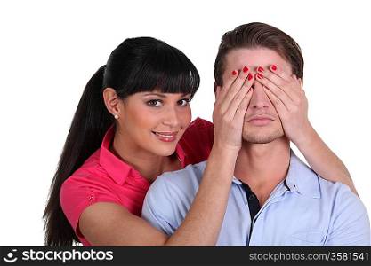 Woman covering a man&acute;s eyes