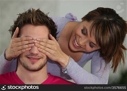 Woman covering boyfriend&acute;s eyes