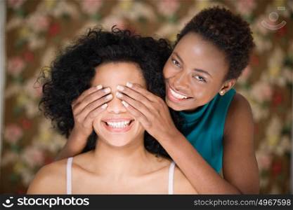 Woman covering friends eyes