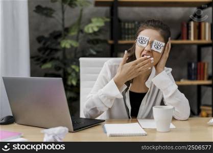 woman covering her eyes with drawn eyes paper