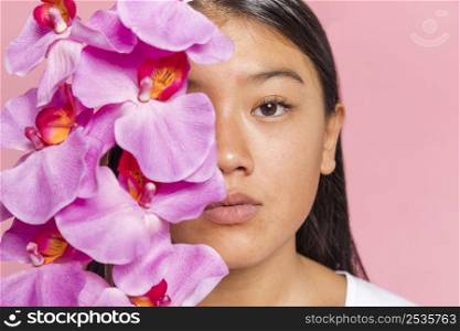 woman covering her face with orchid petals