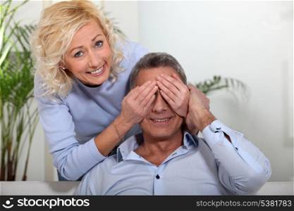 Woman covering her husband&rsquo;s eyes