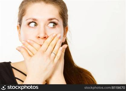 Woman covering her mouth with hand. Seeing something shocking, surprised and speechless face expression.. Woman covering her mouth with hand