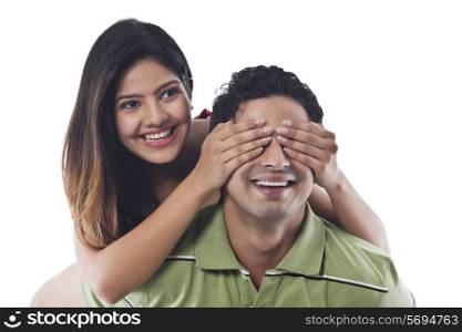 Woman covering mans eyes with her hands