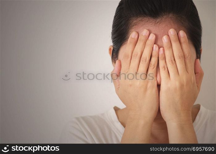 Woman covering up her face with her hands, feeling sad, stressed or depressed. . Woman suffering fromdepression