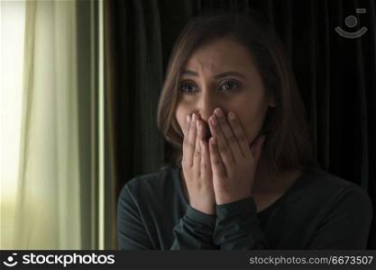 Woman crying with hand over mouth