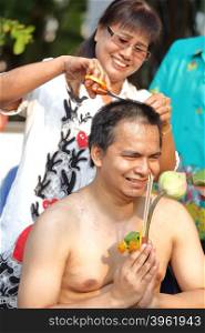 woman cut hair of man for be Ordained to new monk