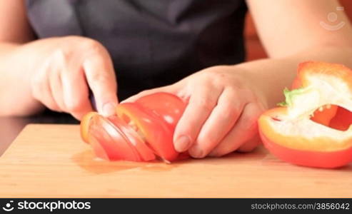 woman cuts pepper for salad.