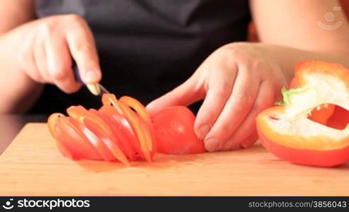 woman cuts pepper for salad.