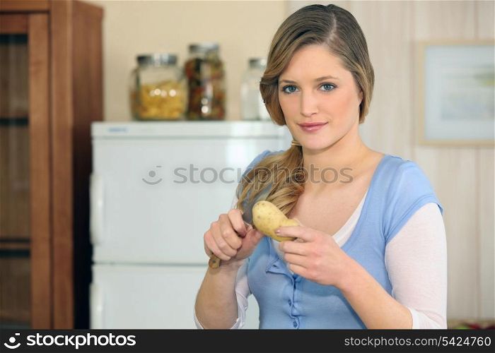 Woman cutting a potato
