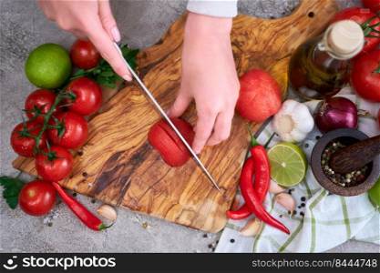 woman cutting and chopping blanched tomato by knife on wooden board.. woman cutting and chopping blanched tomato by knife on wooden board