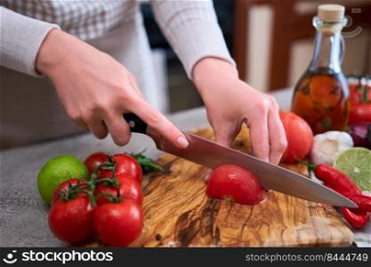 woman cutting and chopping blanched tomato by knife on wooden board.. woman cutting and chopping blanched tomato by knife on wooden board