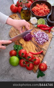 woman cutting and chopping onion by knife on wooden board.. woman cutting and chopping onion by knife on wooden board