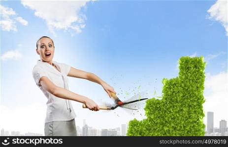 Woman cutting bush. Young happy businesswoman cutting bush shaped like graph. Growth concept